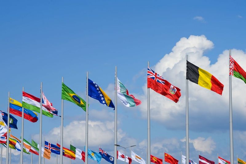 En rad med många flaggstänger med olika nationsflaggor.
