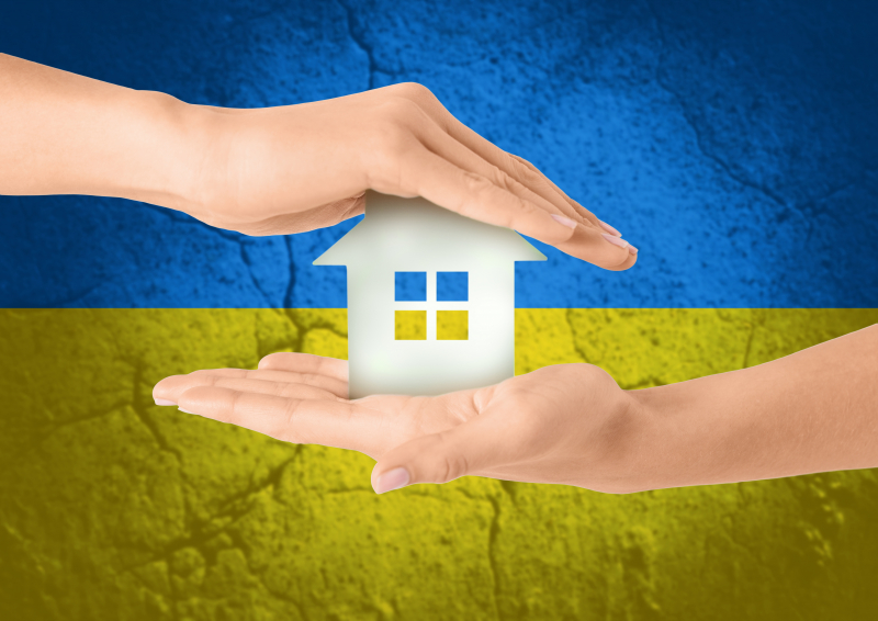 Ukraina flagga och händer som håller ett hus