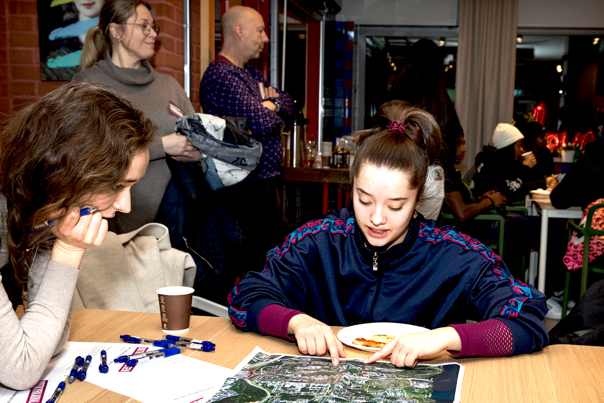 Två kvinnor sitter runt ett bord och tittar på en karta över Botkyrka.