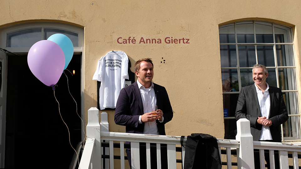 Kommunstyrelsens ordförande Emanuel Ksiazkiewicz (S) talade under firandet på Café Anna Giertz vid Hågelby. Till höger står Kevin Ryan, vd för Tillväxt Botkyrka.