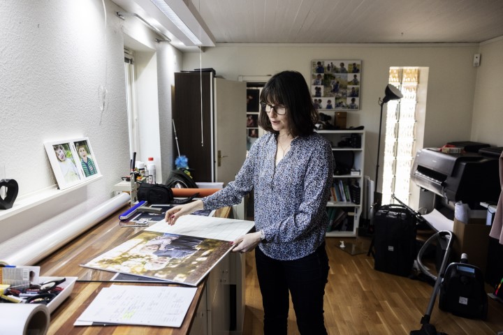 Terri Lindholm blickar ut över ett porträtt i sin studio