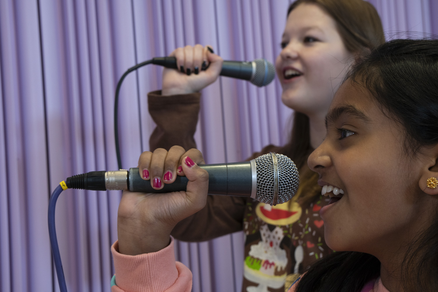 Barn som sjunger i mikrofoner.