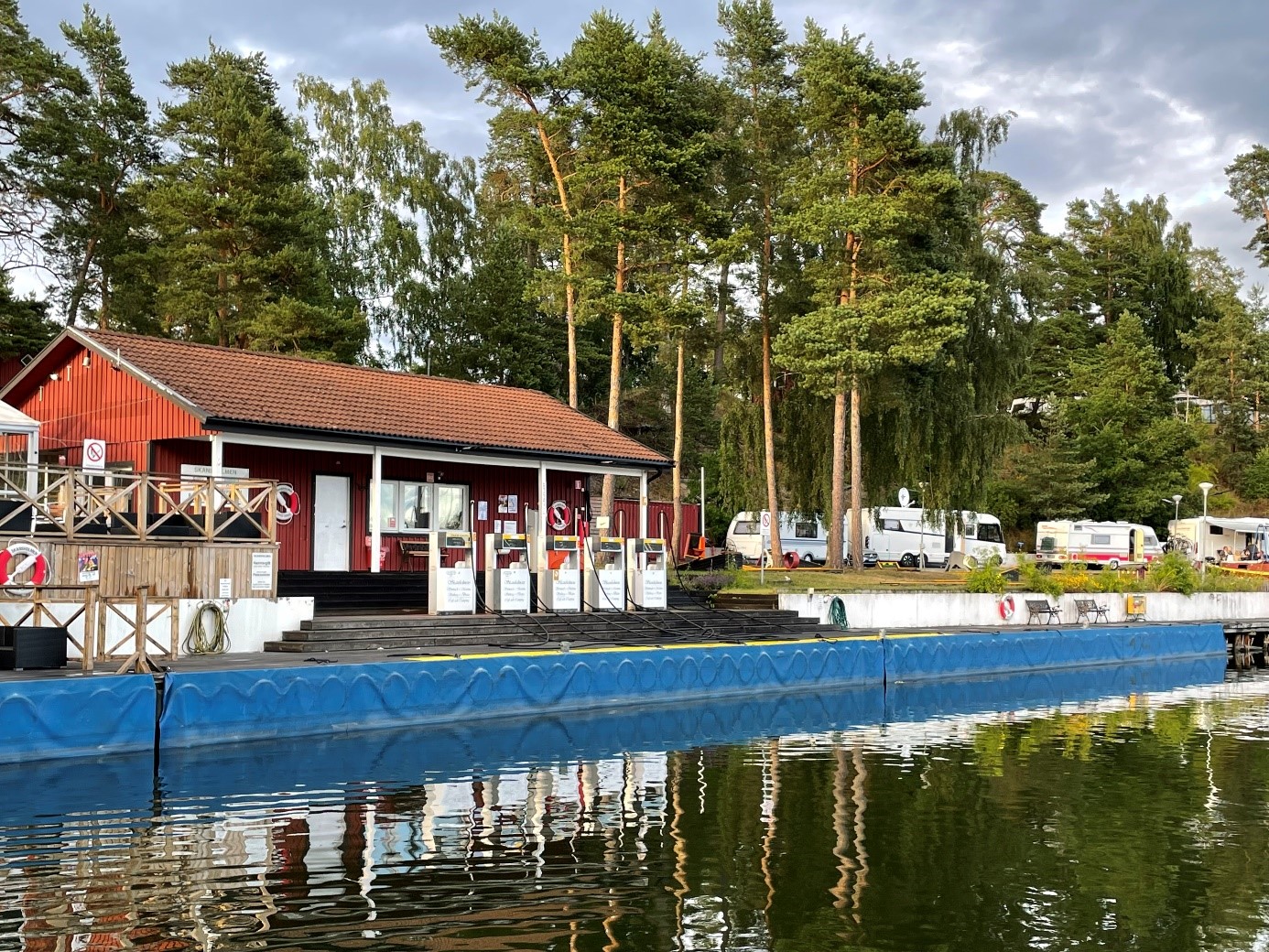 En byggnad och flera husvagnar som står vid vattnet.