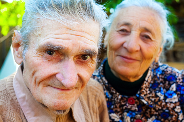 porträtt av manlig och kvinnlig senior som ler mot kameran