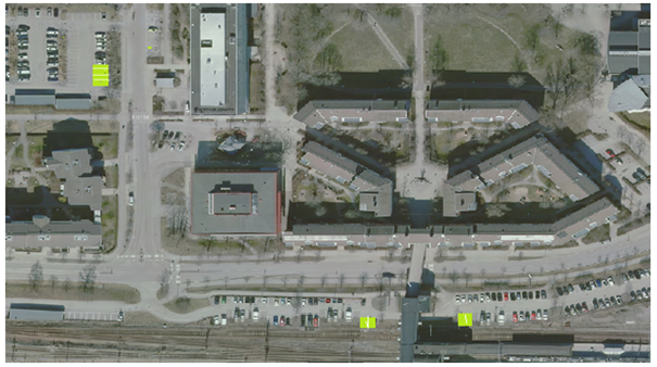 Flygbild över Munkhättevägen och intilliggande parkeringsplatser. 8 gröna parkeringsrutor är utmärkta på bilden. 