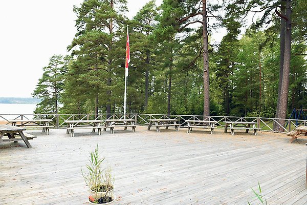 En altan i trä med bänkar och en flaggstång.