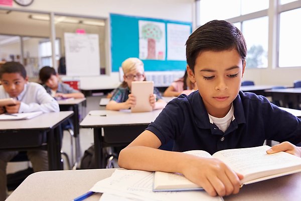 Pojke som läser i ett klassrum