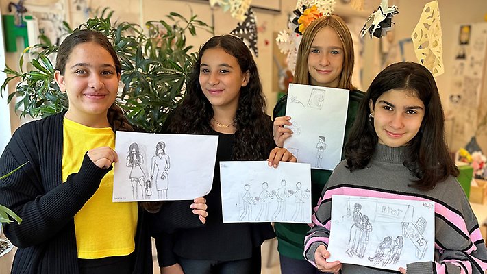 Eleverna Wagma Safi, Maram Assaddiki, Selena Stojanovic och Maya Omar Sami står i bildsalen och visar upp  illustrationer till boken Någons bror.